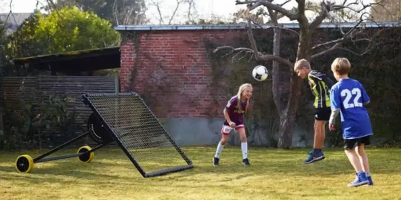 kid practicing soccer with  m-station soccer kickback net trampoline rebounder by Munin Sports