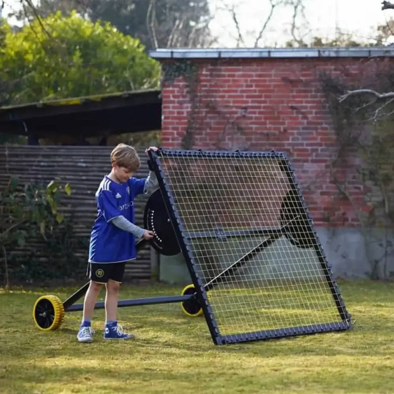 kid setting up m-station soccer kickback net trampoline rebounder by Munin Sports